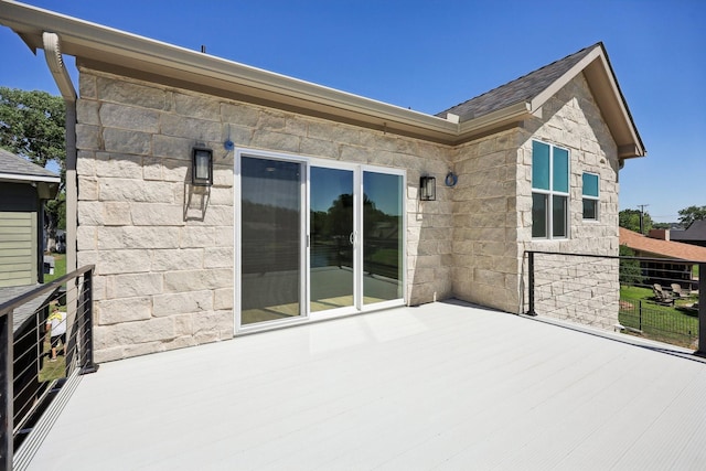 exterior space with stone siding and a balcony