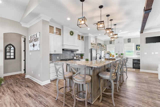 kitchen featuring recessed lighting, backsplash, beverage cooler, and white cabinetry
