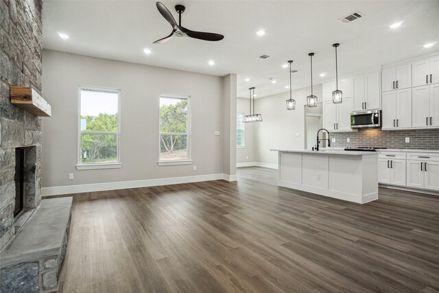 kitchen featuring baseboards, a ceiling fan, visible vents, and stainless steel microwave