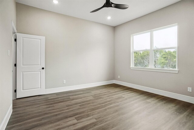 spare room featuring recessed lighting, a ceiling fan, baseboards, and dark wood-style flooring