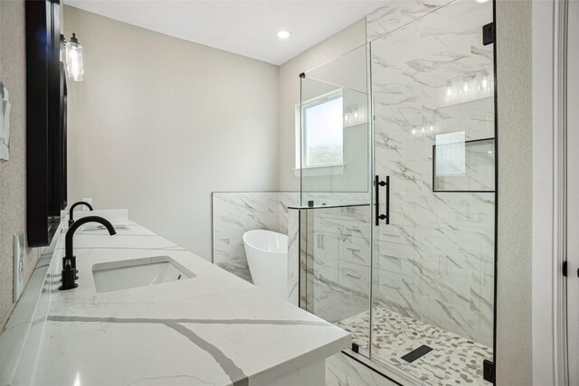 full bathroom featuring a soaking tub, marble finish floor, a marble finish shower, and a sink
