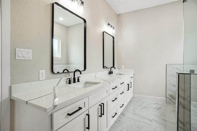 full bath featuring baseboards, marble finish floor, a sink, and double vanity