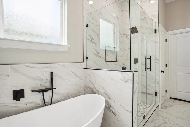 full bathroom with a marble finish shower, marble finish floor, a freestanding bath, and a healthy amount of sunlight