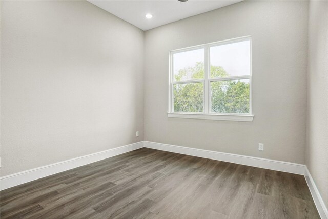 empty room with baseboards, recessed lighting, and dark wood-style flooring