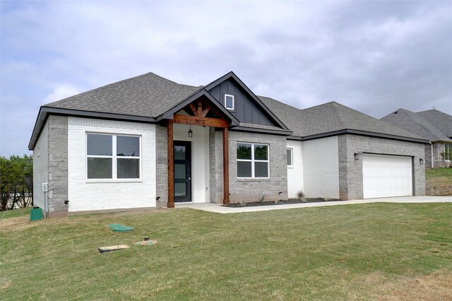 view of front of home featuring a front lawn, board and batten siding, an attached garage, driveway, and roof with shingles