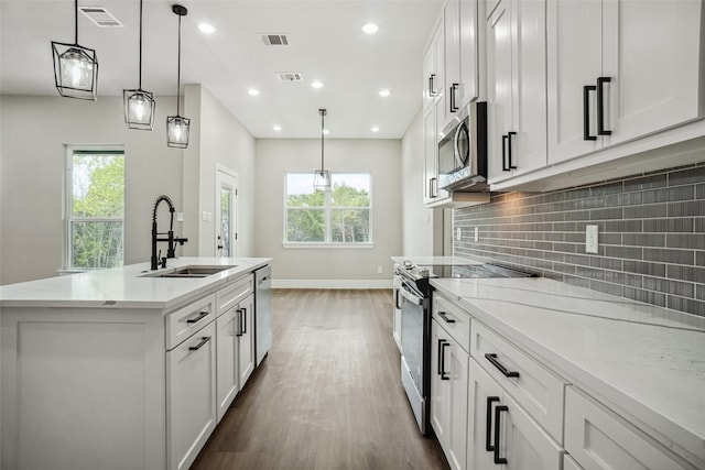 kitchen with wood finished floors, visible vents, appliances with stainless steel finishes, and a sink