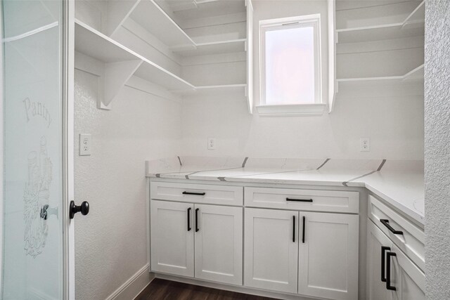 clothes washing area with baseboards and dark wood-style flooring