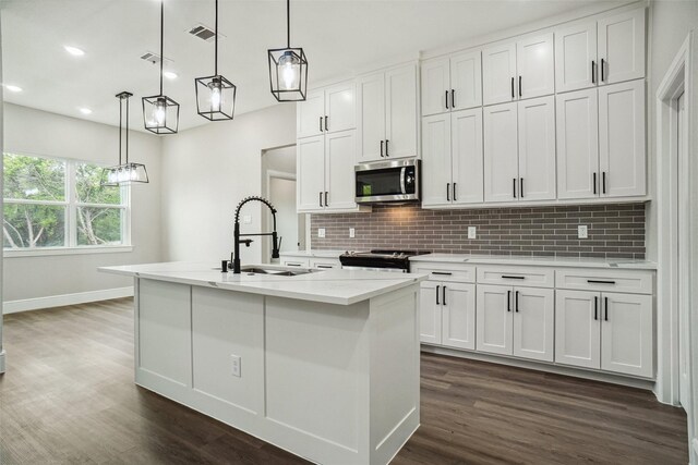 kitchen featuring dark wood finished floors, visible vents, a sink, tasteful backsplash, and appliances with stainless steel finishes