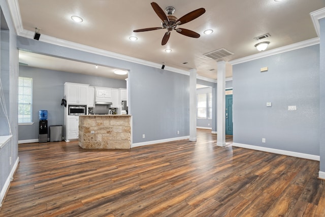 unfurnished living room featuring visible vents, crown molding, and a ceiling fan