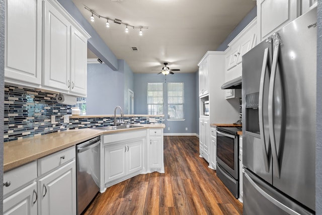 kitchen featuring a sink, ceiling fan, backsplash, a peninsula, and appliances with stainless steel finishes