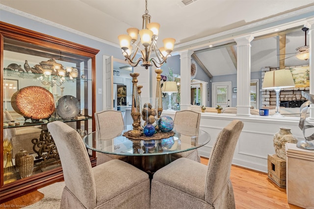 dining room with lofted ceiling with beams, an inviting chandelier, wood finished floors, and decorative columns