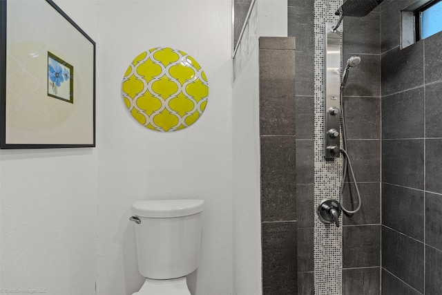 bathroom featuring toilet and tiled shower