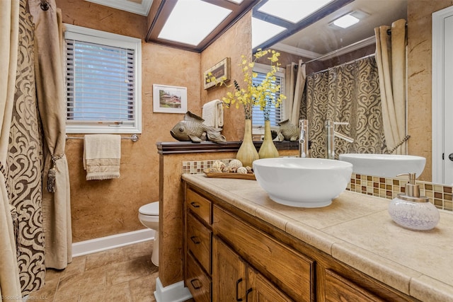 bathroom with a shower with shower curtain, toilet, vanity, and ornamental molding