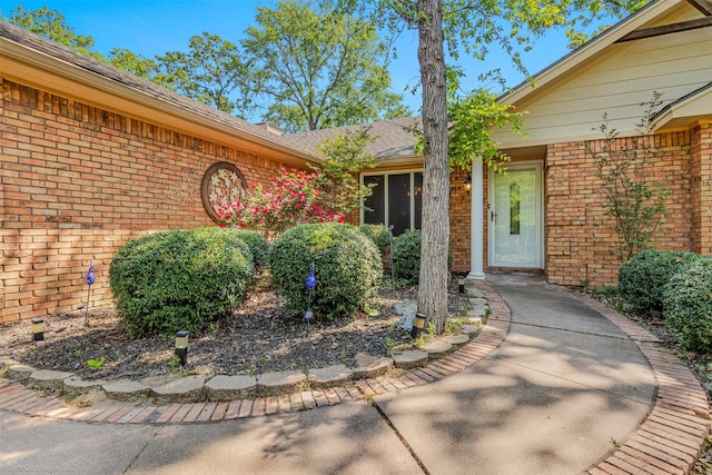 entrance to property featuring brick siding