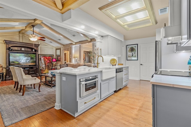 kitchen featuring appliances with stainless steel finishes, gray cabinetry, a sink, and visible vents