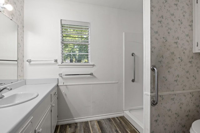 314 Cedar, Mount Pleasant, TX 75455 - bathroom featuring toilet, wallpapered walls, walk in shower, wood finished floors, and vanity