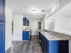 kitchen with blue cabinetry and dark wood-style flooring