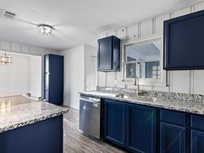 kitchen featuring wood finished floors, stainless steel dishwasher, blue cabinets, and a sink