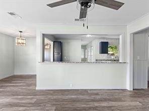 unfurnished living room with visible vents, a ceiling fan, wood finished floors, and crown molding