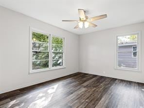 empty room with dark wood-style floors, a wealth of natural light, and ceiling fan