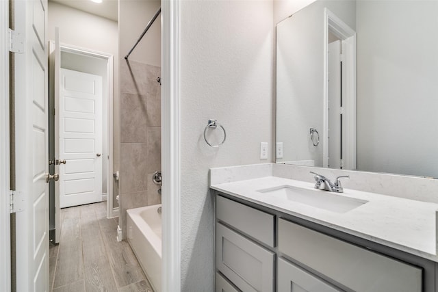 bathroom with shower / bathtub combination, vanity, and wood finished floors