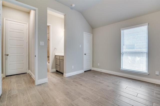 unfurnished bedroom with light wood-type flooring, baseboards, lofted ceiling, and multiple windows