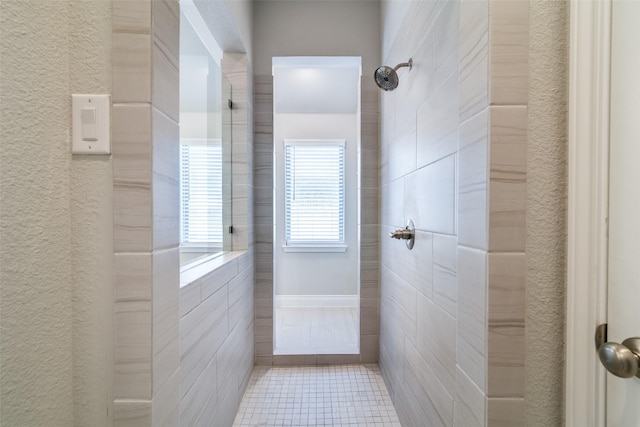 bathroom with tile patterned floors and tiled shower