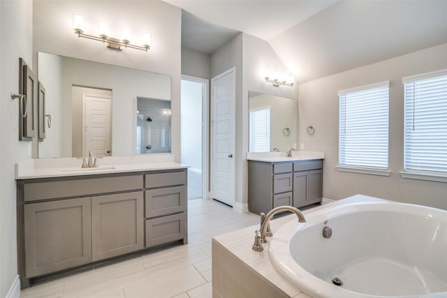 bathroom with two vanities, a garden tub, a sink, and lofted ceiling
