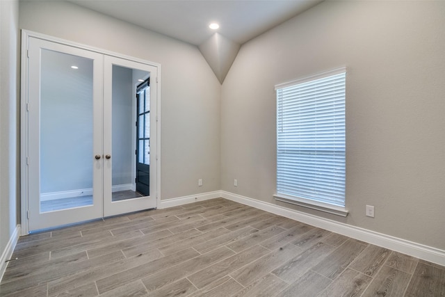 spare room with light wood finished floors, french doors, baseboards, and recessed lighting