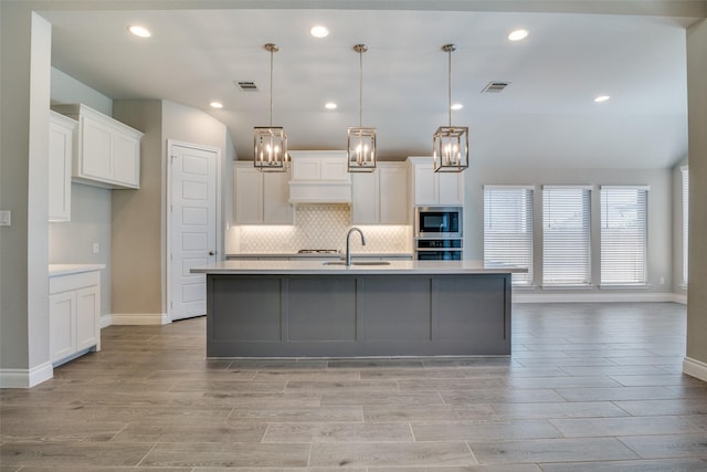 kitchen with appliances with stainless steel finishes, tasteful backsplash, white cabinetry, and light countertops