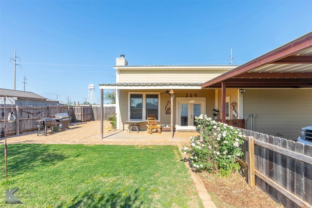 back of property featuring a fenced backyard, a chimney, a lawn, ceiling fan, and a patio