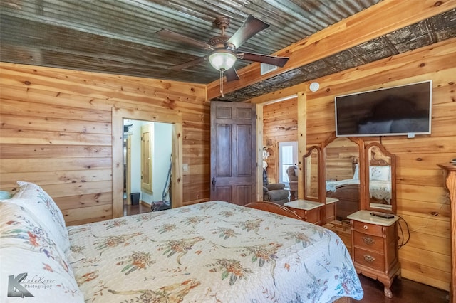 bedroom with ceiling fan and wood walls