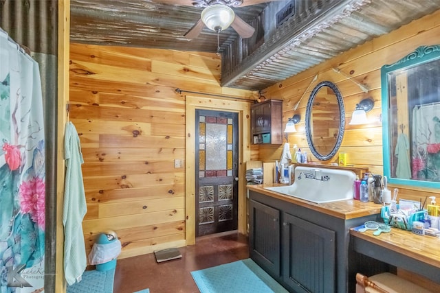 full bathroom with ceiling fan, vanity, and wooden walls