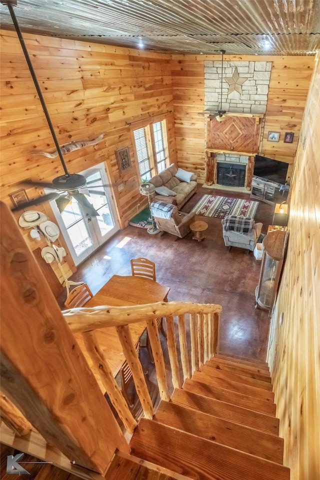 staircase featuring a fireplace, hardwood / wood-style floors, and wood walls