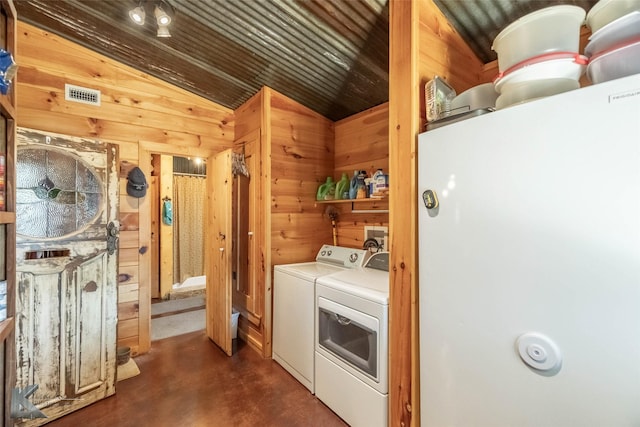 laundry area with wood walls, visible vents, independent washer and dryer, and laundry area