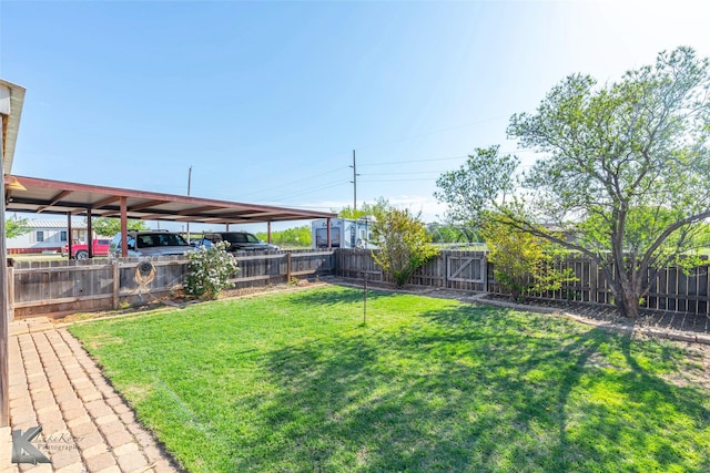 view of yard featuring a fenced backyard and a carport