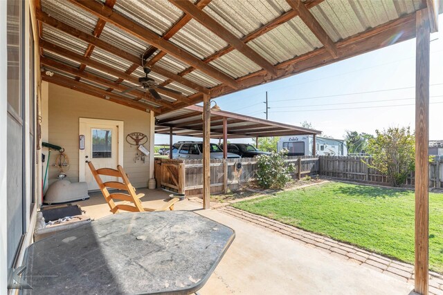view of patio with a carport, a fenced backyard, and a ceiling fan