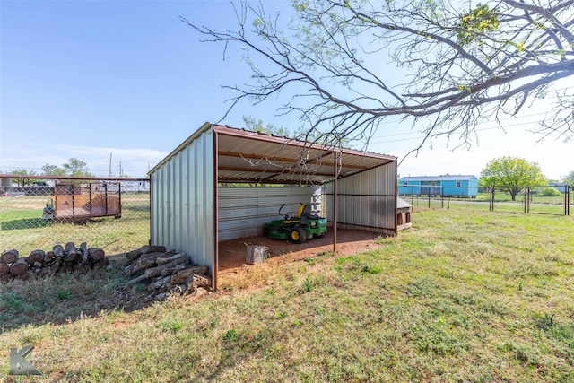 view of pole building with a lawn, fence, and a detached carport