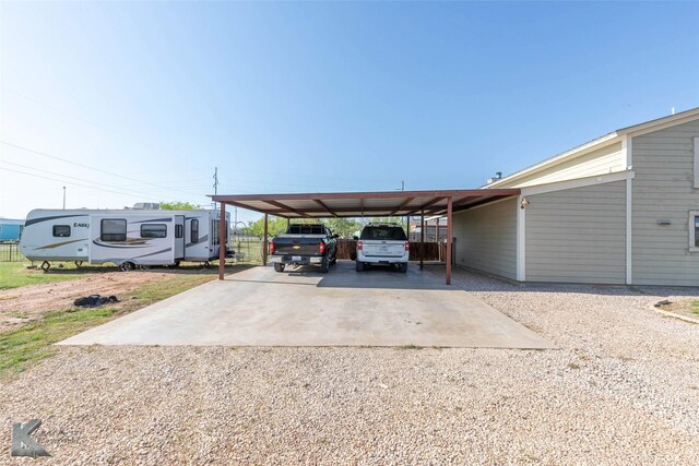 view of car parking with a carport and dirt driveway
