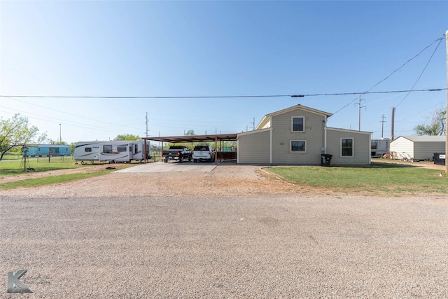 view of front of property with driveway, a front yard, and an attached carport