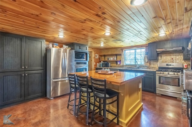 kitchen featuring wood counters, concrete flooring, a sink, and appliances with stainless steel finishes