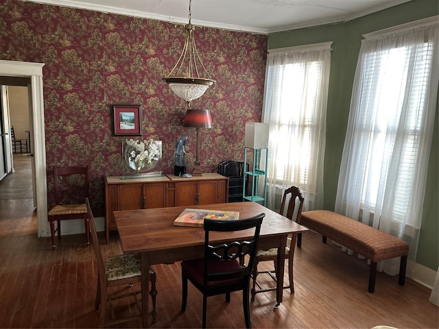 dining room with baseboards, crown molding, and hardwood / wood-style floors