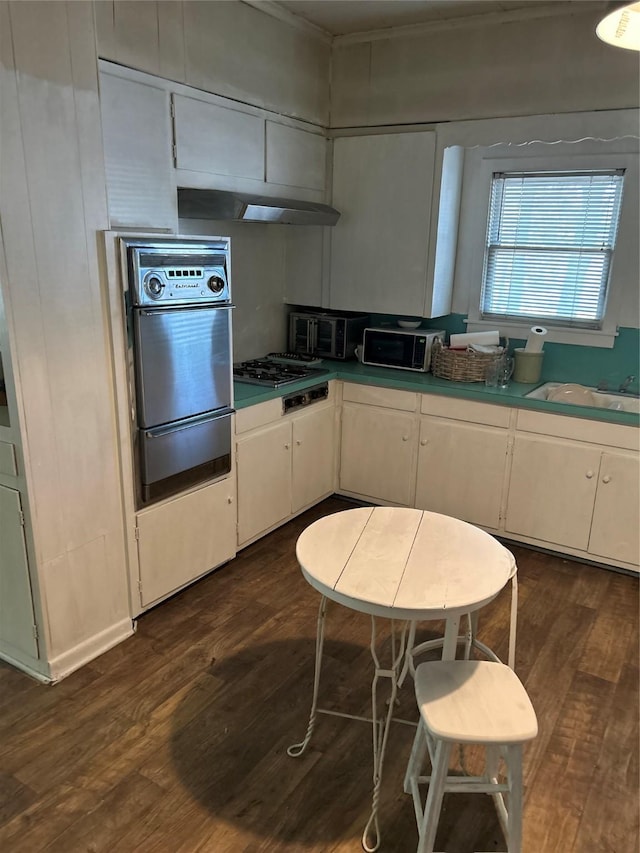 kitchen with oven, a sink, a warming drawer, gas stovetop, and dark wood-type flooring