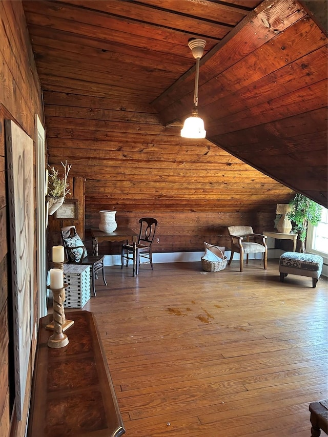 sitting room with lofted ceiling, wooden ceiling, wood walls, and hardwood / wood-style flooring