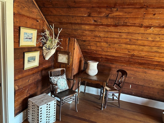 sitting room featuring vaulted ceiling, wooden walls, wooden ceiling, and wood-type flooring