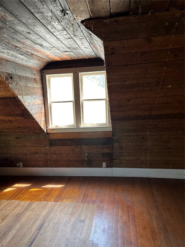 bonus room featuring wood-type flooring and wood walls