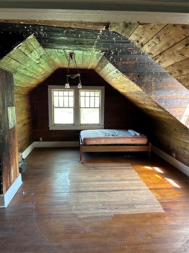 bonus room featuring wood-type flooring, lofted ceiling, wood walls, and baseboards