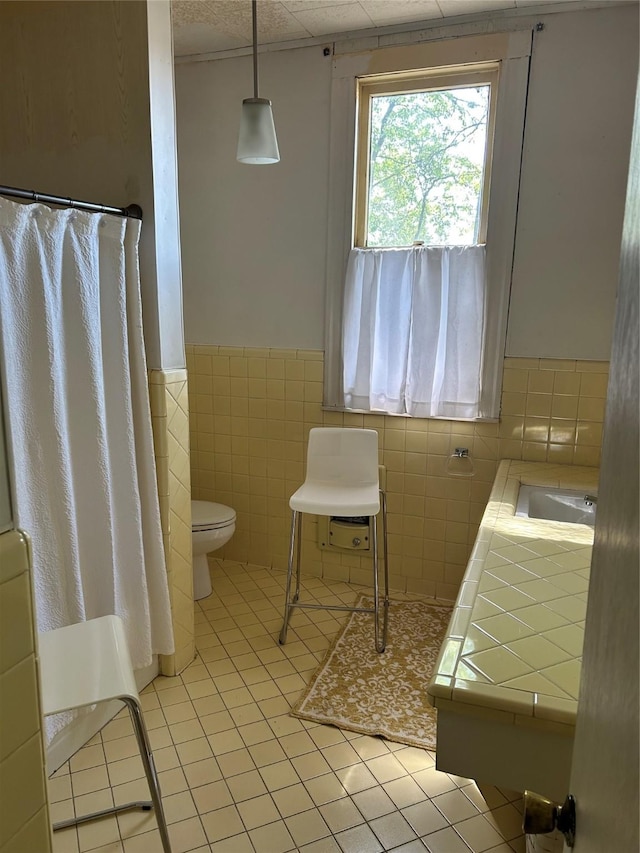 bathroom featuring a sink, tile patterned floors, wainscoting, curtained shower, and toilet