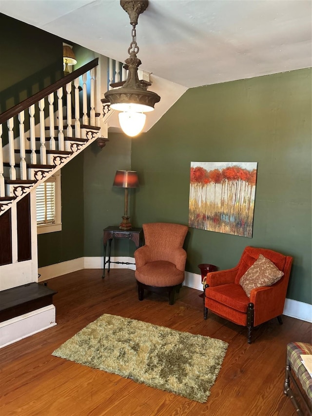 sitting room with vaulted ceiling, wood finished floors, baseboards, and stairway
