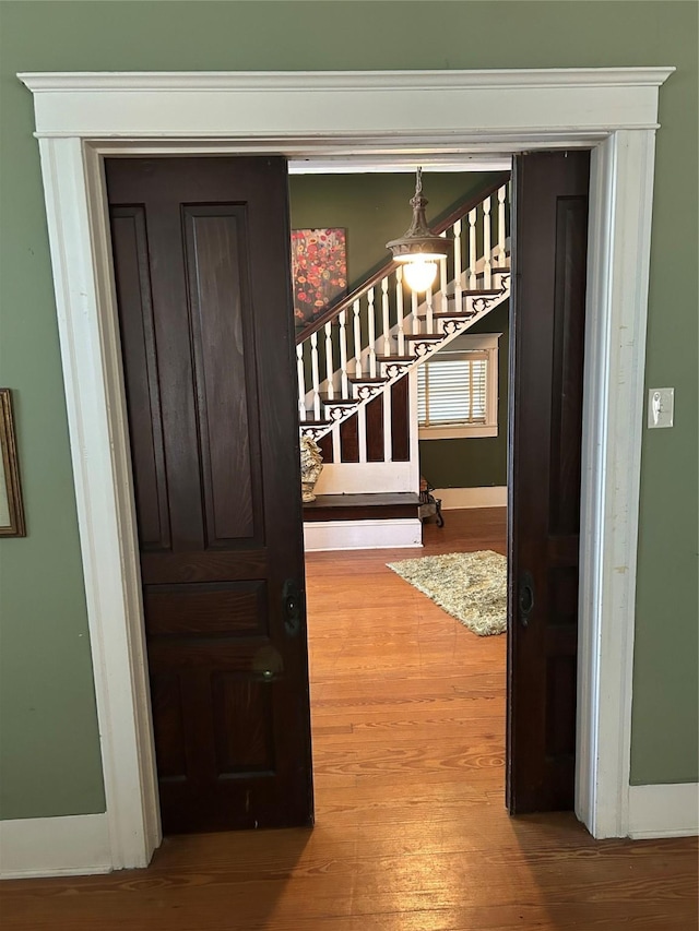 interior space with baseboards, wood finished floors, and stairs